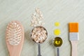 Small scoops with oatmeal and olive oil with wooden hair brush and cosmetic brush. Ingredients for preparing diy masks, scrubs. Royalty Free Stock Photo