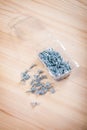 Small screws in plastical box on wooden board Royalty Free Stock Photo