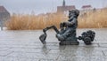 Small sculpture of bronze gnome on digger on Odra River embarkment. Wroclaw. Poland