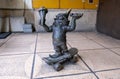 Small sculpture of bronze gnome riding on skateboard with ice cream