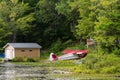 A small seaplane float plane stands at the edge of the lake