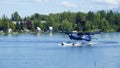 Small seaplane is lifting off from the water to land Royalty Free Stock Photo
