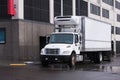 Small semi truck with reefer unit on box trailer for local delivery unloading delivered food Royalty Free Stock Photo