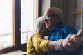 Small senior woman dancing with her husband in the living room and resting her head on his shoulder, holding hands Royalty Free Stock Photo