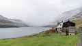 A small settlement village overlooking a fjord surrounded by green mountains Royalty Free Stock Photo