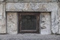 Small shabby basement window in a stone building