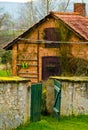 A small shelter from stone bricks in an old garden with a wall in front of it and a green garden gate Royalty Free Stock Photo