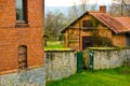 A small shelter from stone bricks in an old garden with a wall in front of it and a green garden gate Royalty Free Stock Photo