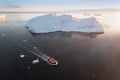 Small ship cruising among ice bergs during beautiful summer day. Disko Bay, Greenland. Royalty Free Stock Photo