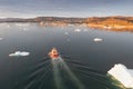 Small ship cruising among ice bergs during beautiful summer day. Disko Bay, Greenland Royalty Free Stock Photo