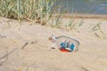 Small ship in the glass bottle lying on the sandy beach Royalty Free Stock Photo