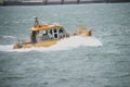 Small ship of the KRVE, organization for the mooring and unmooring of sea-going ships, with high waves in the port of Rotterdam.