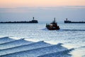 A small ship leaves the port through the pier gate Royalty Free Stock Photo