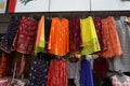 Small shop owner indian man selling shawls, clothing and souvenirs at his store. Colorful traditional Indian costume/outfit for Royalty Free Stock Photo