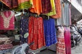 Small shop owner indian man selling shawls, clothing and souvenirs at his store. Colorful traditional Indian costume/outfit for Royalty Free Stock Photo