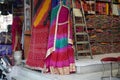 Small shop owner indian man selling shawls, clothing and souvenirs at his store. Colorful traditional Indian costume/outfit for Royalty Free Stock Photo