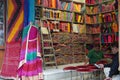 Small shop owner indian man selling shawls, clothing and souvenirs at his store. Colorful traditional Indian costume/outfit for Royalty Free Stock Photo