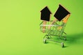 Small shopping cart with tags on color background Royalty Free Stock Photo