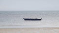 Small short blue wooden boat for fishing and transporting tied up at the shallow sea Royalty Free Stock Photo