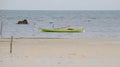 Small short green wooden boat for fishing and transporting tied up at the beach Royalty Free Stock Photo