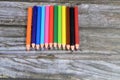 small short wood color pencils of different colors for painting isolated on wooden background, back to school concept, school