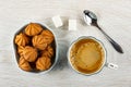 Small shortbread cookies in bowl, sugar, spoon, black coffee in cup on wooden table. Top view Royalty Free Stock Photo