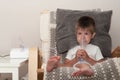 Small sick boy with nebulizer mask making inhalation, respiratory procedure by pneumonia or cough for child in home. Treatment at Royalty Free Stock Photo