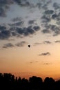 Small silhouette of a hot air balloon on the background of dawn. Vertical photo of the sky with clouds Royalty Free Stock Photo