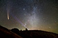 Small silhouette of a scientist with flashlight on his head pointing bright beam of light on starry sky with C/2020 F3 NEOWISE Royalty Free Stock Photo