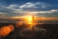 Small silhouette of a woman practicing yoga on sea beach Royalty Free Stock Photo