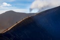 Small silhouettes of people on the edge of the crater of the active volcano Bromo. The power of nature. Indonesia.