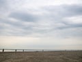 Small silhouettes of people on the shore. People in the distance stand and look at the sea. Out of season at the Black Sea Royalty Free Stock Photo