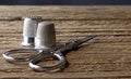 SMALL SILVER COLORED SCISSORS AND TWO SHINY METAL THIMBLES