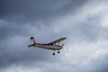 Small single engine airplane flying in the english cloudy sky