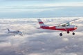 Small single engine airplane flying in the gorgeous sunset sky through the sea of clouds above the spectacular mountains Royalty Free Stock Photo