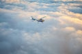 Small single engine airplane flying in the gorgeous sunset sky through the sea of clouds Royalty Free Stock Photo