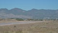 Small single engine training aircraft taking off from Aeroclub of Castello with mountains in background