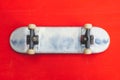 Small skateboard on red background. tiny skate for fingers. fingerboard close up