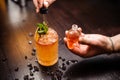 Small skull-shaped bottle, summer cocktail and barmen hand