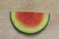 Small slice of seedless watermelon, centered on a worn bamboo cutting board Royalty Free Stock Photo