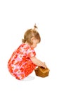 Small smiling baby in red dress with toy basket Royalty Free Stock Photo