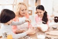 Small smiling boy is whipping eggs in bowl with his sister and grandmother Royalty Free Stock Photo