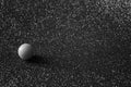 A small smooth ball on a silvery background. An example of asymmetry. Symbolism. Black and white photography. Shallow depth of