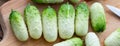 Small snack cocktail Dutch cucumbers Quirk variety on wooden background, selective focus