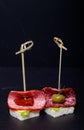 Small snacks canape with salami, bread and lettuce on skewer on Royalty Free Stock Photo