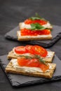 Small snacks of slices, curd cheese, red fish, tomatoes and caviar. On stone Royalty Free Stock Photo