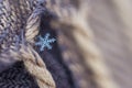 A small snowflake fell on the canvas beige-brown scarf and caught on the fringe as if hiding