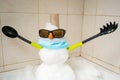 Small snowman built inside a shower with cutlery for hands.