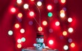 Small snowman toy on front of red bokeh Royalty Free Stock Photo