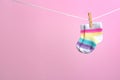 Small socks hanging on washing line against color background. Baby accessories Royalty Free Stock Photo